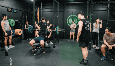 Coach assisting a gym member while doing bench press at the Habitat Gym in Prestons
