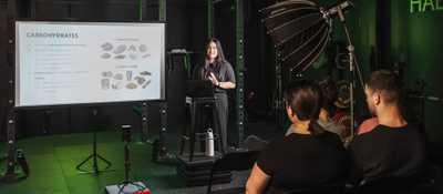 Coach leading a nutrition workshop at Habitat Gym, explaining the role of carbohydrates in fitness and performance