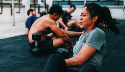 Asian woman doing weighted Russian twist in Habitat Gym