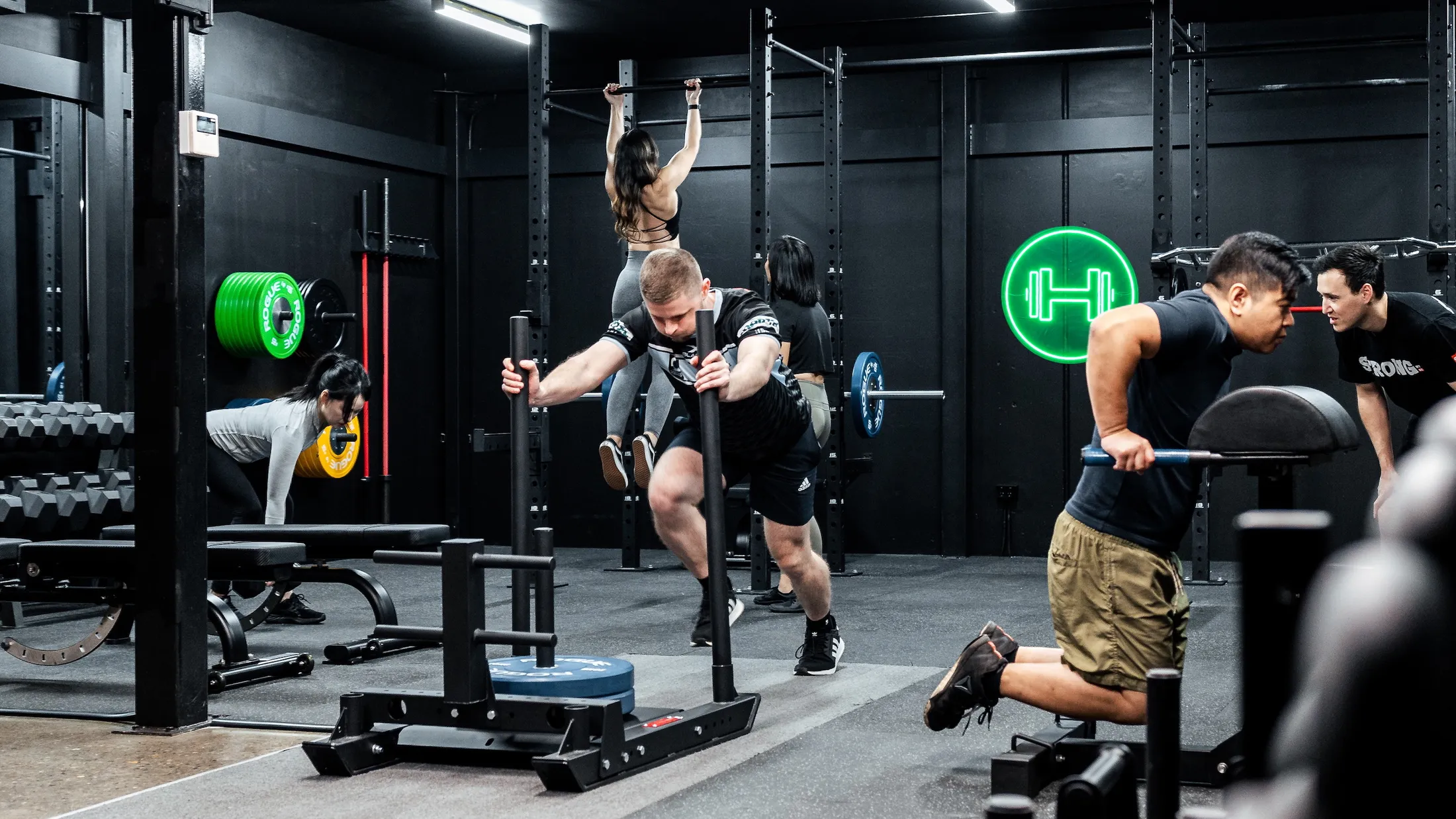 Personal trainer coaching group of four members during strength training session in Habitat Prestons gym