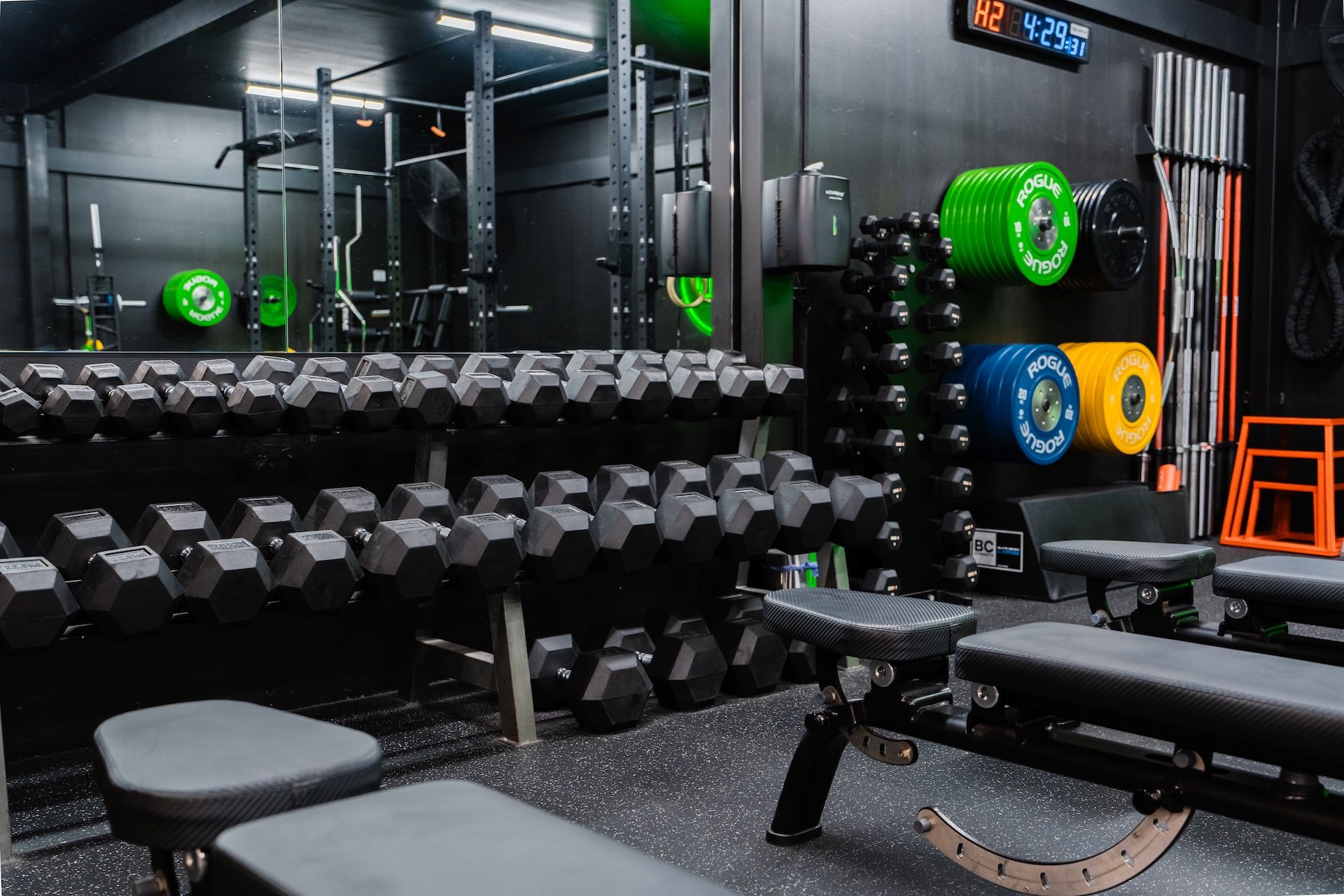 Brand new free weights organised and lined up alongside rack plates and lifting barbells in Habitat Gym in Prestons