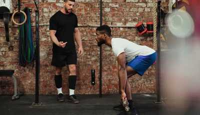 Man learning how to deadlift at the Gym with strength training coach