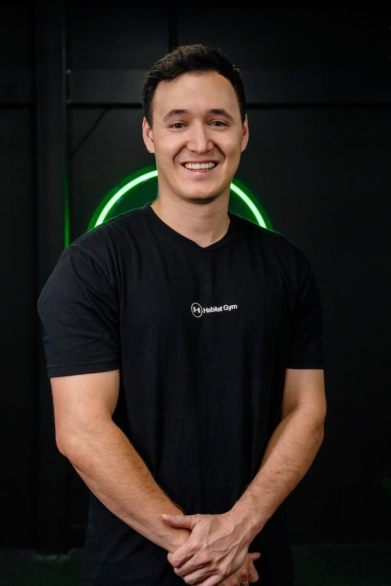 Ben Luo, co-founder and head coach coach at Habitat Gym, smiling inside the Prestons facility