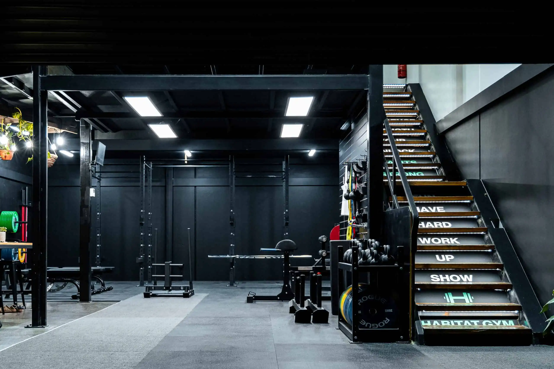 Habitat Gym Prestons stairs with motivational phrases on each step beside strength training equipment