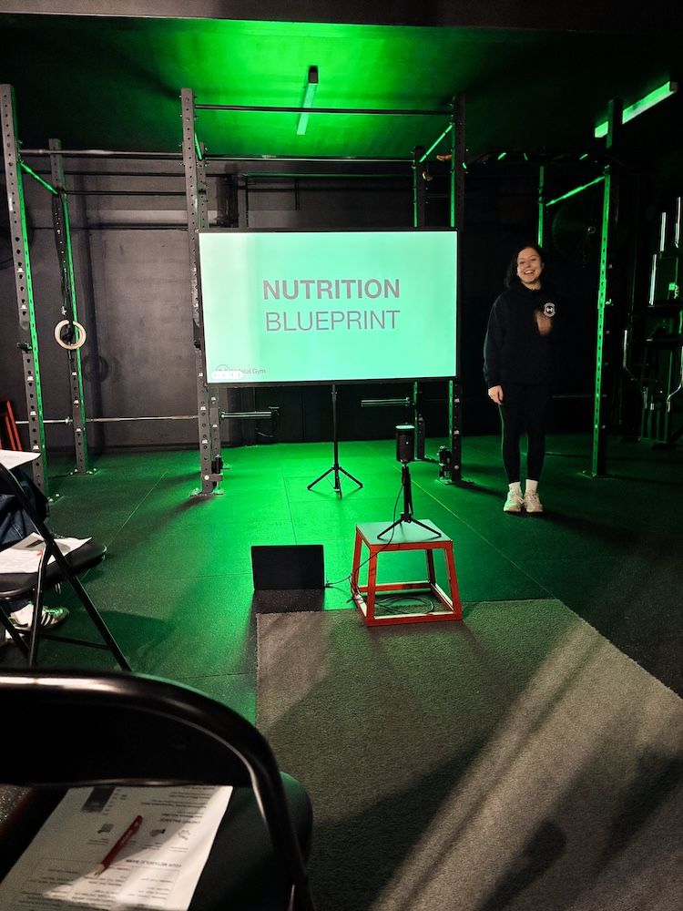 Coach leading the Nutrition Blueprint Workshop with members at Habitat Gym in May 2025